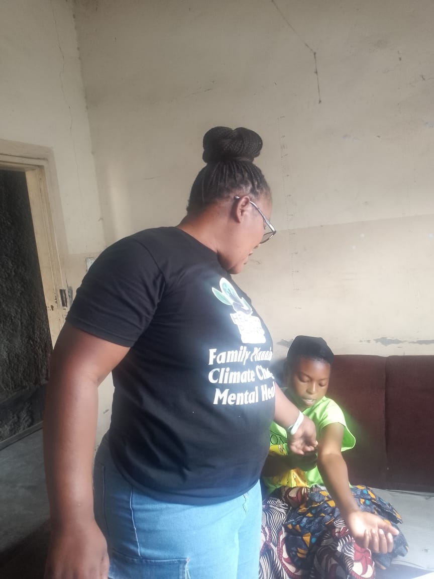 Health Planet Foundation staff member speaking with a mother during a home visit